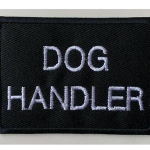 Può includere: Toppa ricamata nera con testo bianco che recita "DOG HANDLER".