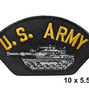 Puede incluir: Parche bordado negro con el texto "U.S. ARMY" en amarillo, sobre una ilustración detallada de un tanque. Mide 10 x 5,5 cm.