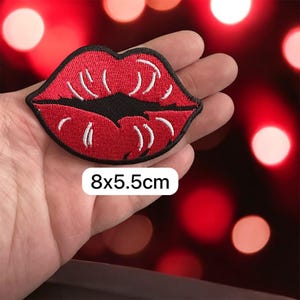 Puede incluir: Parche bordado de labios rojos con detalles blancos y contorno negro. Mide 8x5,5 cm. Este parche decorativo se puede planchar o coser en ropa, bolsos u otros artículos de tela.