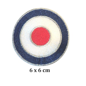 May include: Circular embroidered patch with a bullseye design. The patch has a red centre, a white ring, and a navy blue outer ring. The patch measures 6 x 6 cm.