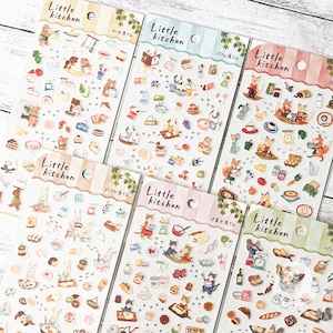 May include: A collection of sticker sheets featuring the text "Little Kitchen" and various illustrations. The stickers depict animals like bears, dogs, foxes, rabbits, and cats, along with kitchen-related items such as food, utensils, and appliances.