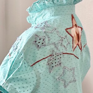 May include: A white ceramic mug with a black handle and the text "But First, Coffee" in a black, handwritten-style font. The mug is on a white surface.