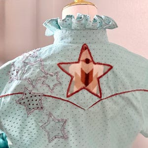 May include: A white ceramic mug with a black handle and the text "But First, Coffee" in a black, bold font. The mug is on a white surface.