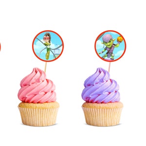 Puede incluir: Cuatro cupcakes con glaseado de diferentes colores y adornos con personajes de la serie animada, PJ Masks. Los adornos son redondos y tienen bordes rojos. Los cupcakes est&aacute;n sobre un fondo blanco.