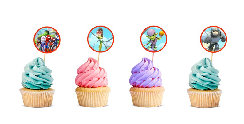 Puede incluir: Cuatro cupcakes con glaseado de diferentes colores y adornos con personajes de la serie animada, PJ Masks. Los adornos son redondos y tienen bordes rojos. Los cupcakes est&aacute;n sobre un fondo blanco.