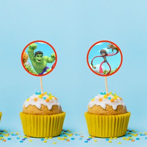 Puede incluir: Cuatro cupcakes con glaseado amarillo y chispas de colores coronados con im&aacute;genes comestibles redondas de superh&eacute;roes. Las im&aacute;genes incluyen Hulk, un superh&eacute;roe con brazos extensibles, y Black Panther.