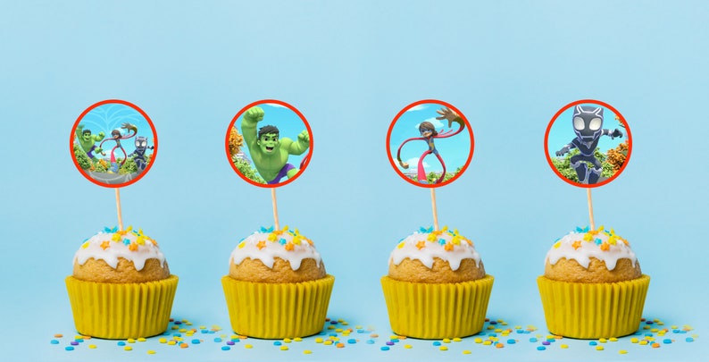 Puede incluir: Cuatro cupcakes con glaseado amarillo y chispas de colores coronados con im&aacute;genes comestibles redondas de superh&eacute;roes. Las im&aacute;genes incluyen Hulk, un superh&eacute;roe con brazos extensibles, y Black Panther.