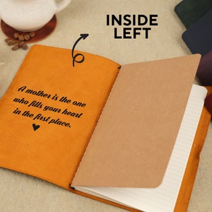Peut inclure: Un journal reli&eacute; en cuir marron avec une citation sur la couverture : "Une m&egrave;re est celle qui remplit votre c&oelig;ur en premier lieu." Le journal est ouvert sur une page blanche avec du papier lign&eacute;.