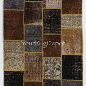 May include: A patchwork rug with a variety of colors and patterns, including brown, black, beige, and gray. The rug is made up of smaller squares of fabric that have been sewn together. The rug has a distressed look and is perfect for adding a touch of vintage style to any room.