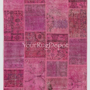 May include: A rectangular patchwork rug in shades of pink and magenta. The rug is composed of various rectangular patches sewn together, each with a unique pattern or texture. The text "YourRugDepot" is printed on the rug.