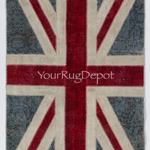 Könnte beinhalten: Ein Patchwork-Teppich mit dem Design der Union Jack-Flagge. Der Teppich besteht aus verschiedenen Stoffen in den Farben Rot, Weiß und Blau. Der Teppich ist mit weißem Garn zusammengenäht. Der Teppich hat einen abgenutzten Look, wobei einige Stoffe ausgefranst und abgenutzt sind. Der Teppich ist perfekt, um jedem Raum einen Hauch von britischem Stil zu verleihen.