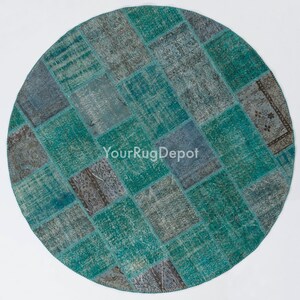 May include: A round patchwork rug with a teal and gray color scheme. The rug is made of various pieces of fabric sewn together in a checkered pattern.