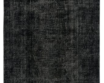 May include: A rectangular black rug with a distressed, textured finish. The rug has a faded appearance with subtle tonal variations, giving it a vintage look. Suitable for living rooms, bedrooms, or hallways. The rug's dimensions are in centimetres.