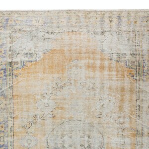May include: A vintage rug with a faded orange and cream colour scheme. The rug has a floral pattern and a border with a blue and green design.