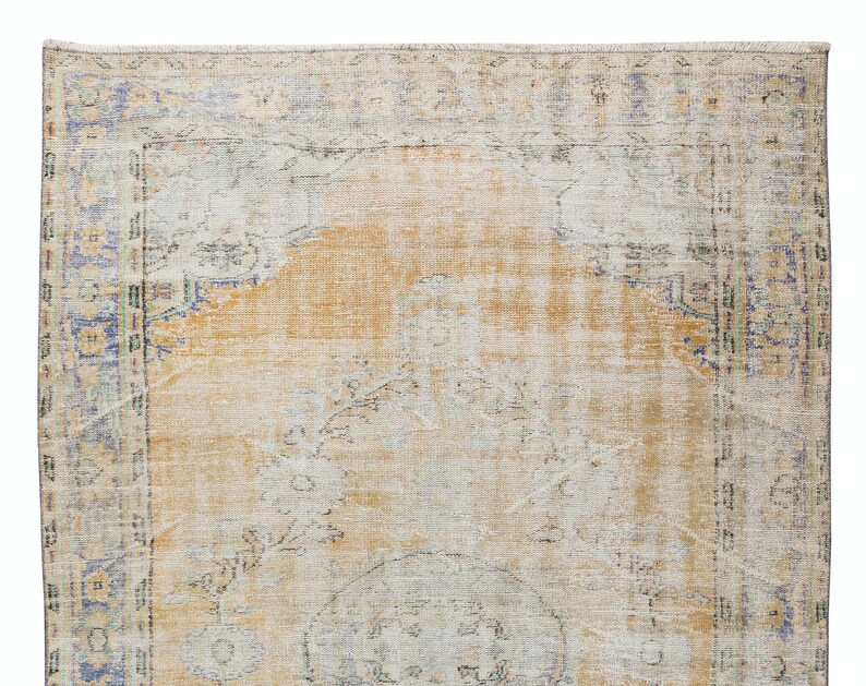 May include: A vintage rug with a faded orange and cream colour scheme. The rug has a floral pattern and a border with a blue and green design.