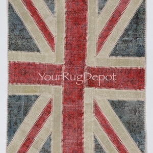 May include: A patchwork rug with the Union Jack flag design. The rug is made of different colored fabrics, including red, white, and blue. The rug is stitched together with white thread. The rug has a distressed look, with some of the fabric being frayed and worn. The rug is a great way to add a touch of British style to your home.