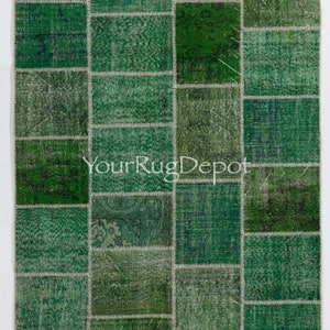 May include: A green patchwork rug with a variety of textures and patterns. The rug is made up of many different squares of fabric, each with a unique design. The rug is perfect for adding a touch of color and style to any room.