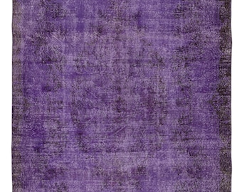 May include: A rectangular, distressed-look rug with a predominantly purple hue. The rug features a darker, almost black, border and subtle patterns throughout. The overall design suggests a vintage or antique aesthetic.