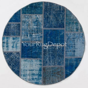 Può includere: Un tappeto rotondo in patchwork con una varietà di tonalità blu e grigie. Il tappeto è realizzato con materiali riciclati e ha un aspetto vissuto. Il tappeto è perfetto per aggiungere un tocco di stile bohémien a qualsiasi stanza.