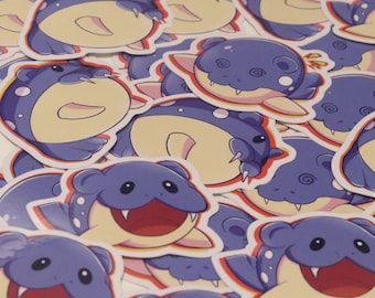 May include: A collection of colorful stickers featuring a cartoon character with a purple body, yellow belly, and a wide open mouth with sharp teeth. The character has large eyes and a few white spots on its body.