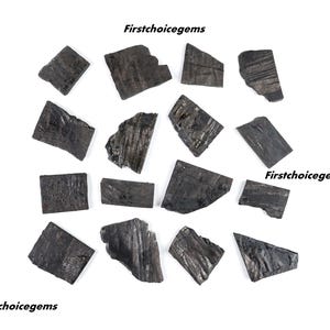 May include: A collection of sixteen dark grey, flat, rectangular and irregularly shaped stone pieces with textured surfaces. The text Firstchoicegems is visible in black lettering at the top, middle right, and bottom left of the image.