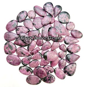 May include: A collection of 30 pink and black gemstone cabochons in various shapes and sizes. The cabochons are all smooth and polished, and they have a natural, organic look.  FirstChoiceGems