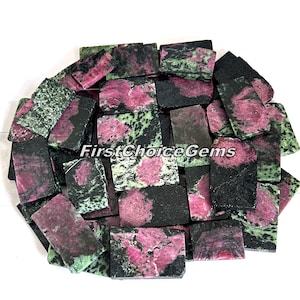 Pode incluir: Uma coleção de lascas de pedras preciosas verdes, rosas e pretas. As lascas são retangulares e têm um acabamento áspero e natural. FirstChoiceGems