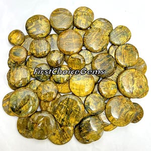 Op de afbeelding: Een verzameling van 30 ronde, gepolijste tijgeroog-cabochons. De stenen zijn een mix van goudgeel en bruin met een gestreept patroon.