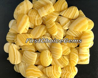 May include: A collection of 25 yellow and white banded agate cabochons in various shapes, including teardrop, oval, and rectangular. The stones are polished and have a smooth, glossy finish.