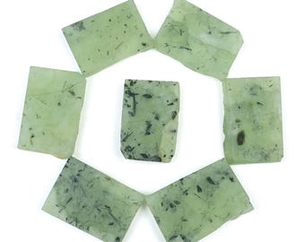 May include: Seven rectangular, pale green gemstone slabs arranged in a circular pattern. Each piece features unique dark, needle-like inclusions scattered throughout the translucent stone. The text Firstchoicegems appears twice.
