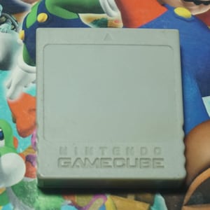 May include: A gray Nintendo GameCube game cartridge with the text "NINTENDO GAMECUBE" printed on the bottom.