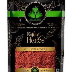 May include: A black packet of "Gule Anar Powder" from "Sai Herbs". The packaging includes a green stripe, gold leaf design, and the words "Raw, Authentic, Plant Based, Non GMO, Gluten Free". The powder is a deep red colour.