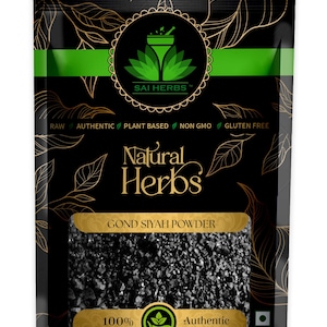 Puede incluir: Bolsa negra de "Gond Siyah Powder" de Sai Herbs. El embalaje es negro con diseños de hojas doradas y detalles verdes. El texto "Natural Herbs" se muestra de forma destacada. El producto está etiquetado como crudo, auténtico, vegetal, sin OGM y sin gluten.
