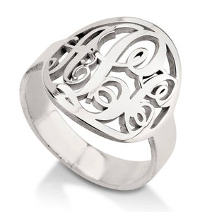 K&ouml;nnte beinhalten: Ein silberner Ring mit einem Monogramm-Design. Der Ring ist aus Sterlingsilber gefertigt und hat ein zartes, filigranes Design.