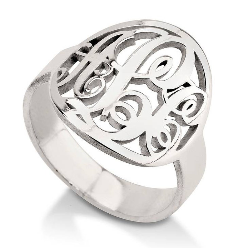 K&ouml;nnte beinhalten: Ein silberner Ring mit einem Monogramm-Design. Der Ring ist aus Sterlingsilber gefertigt und hat ein zartes, filigranes Design.