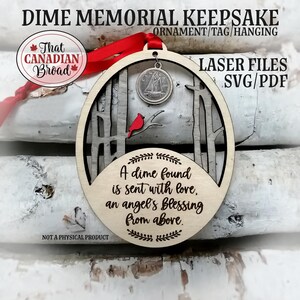 Könnte beinhalten: Holzornament „Dime Memorial Keepsake“ mit rotem Band. Das Ornament zeigt einen Dime, einen roten Kardinal und den Text „A dime found is sent with love, an angel's blessing from above“. Der Text „That Canadian Broad“ ist ebenfalls sichtbar.