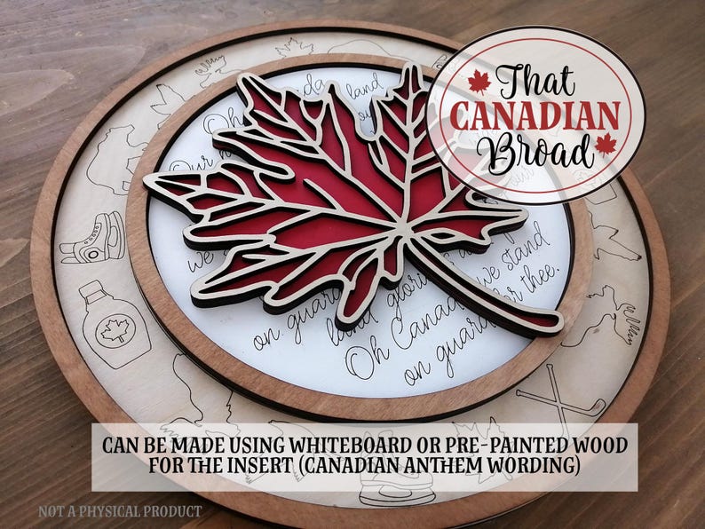 Op de afbeelding: Een rond houten bord met een rode esdoornbladuitsparing en de tekst "That CANADIAN Broad" in een witte cirkel. Het bord bevat ook de tekst van het Canadese volkslied "Oh Canada!" in cursief schrift. Het bord is gemaakt met whiteboard of voorgeschilderd hout voor de inzet.