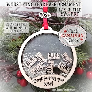 May include: A round wooden Christmas bauble with a shaker style design. The bauble has a clear window revealing glitter and the words "Worst fucking year ever!" and "F*ck this" repeated several times. The bauble is decorated with a red ribbon and the year 2024. The text "That Canadian Broad" is also visible on the bauble.