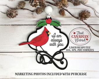 May include: A wooden Christmas ornament featuring a red cardinal bird with the text "I am always with you". The ornament is decorated with a green holly sprig and a white bead at the top. The ornament is laser cut and comes in SVG, EPS, and PDF formats.