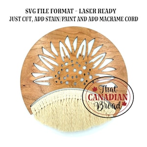 May include: A round wooden wall hanging with a sunflower design cut out. The top portion is wood, and the bottom has a cream-colored macrame fringe. Text on the image reads: SVG FILE FORMAT - LASER READY JUST CUT, ADD STAIN/PAINT AND ADD MACRAME CORD.