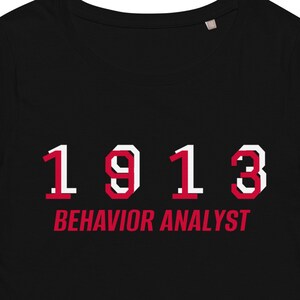 May include: Black t-shirt with white text that reads "1913 BEHAVIOR ANALYST" in a retro font.