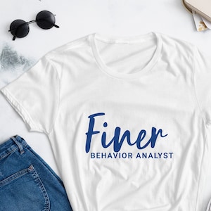 May include: White t-shirt with blue text that says "Finer Behavior Analyst".
