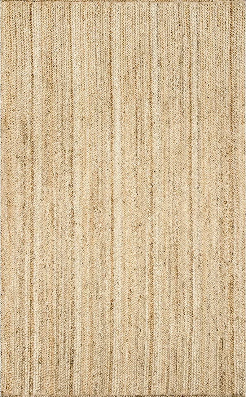 May include: A natural fiber rug with a woven texture in a light beige color.
