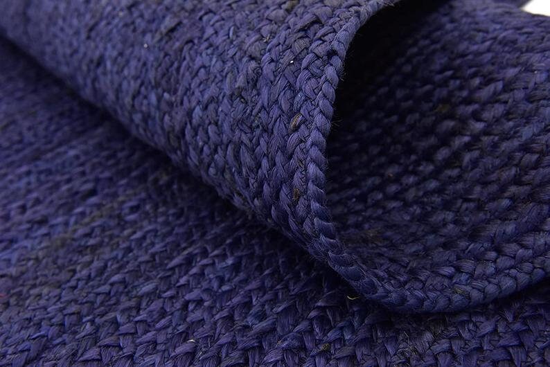 May include: Close-up of a dark blue woven rug made of natural fibers. The rug has a textured surface and a slightly rough feel.