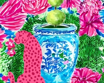 May include: A pink cheetah figurine sits in front of a blue and white porcelain ginger jar with a green floral arrangement on top. The background is a vibrant green and pink floral pattern.