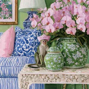 May include: A painting of a small monkey wearing a pink hat sitting on a textured table next to a green and white floral ginger jar. A large bouquet of pink orchids sits in a matching jar. A blue and white patterned pillow rests on a striped sofa.