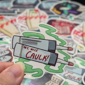 May include: A sticker with a cartoon image of two tubes of caulk with green goo coming out of them. The text on the sticker says "Hey, nice caulk!"