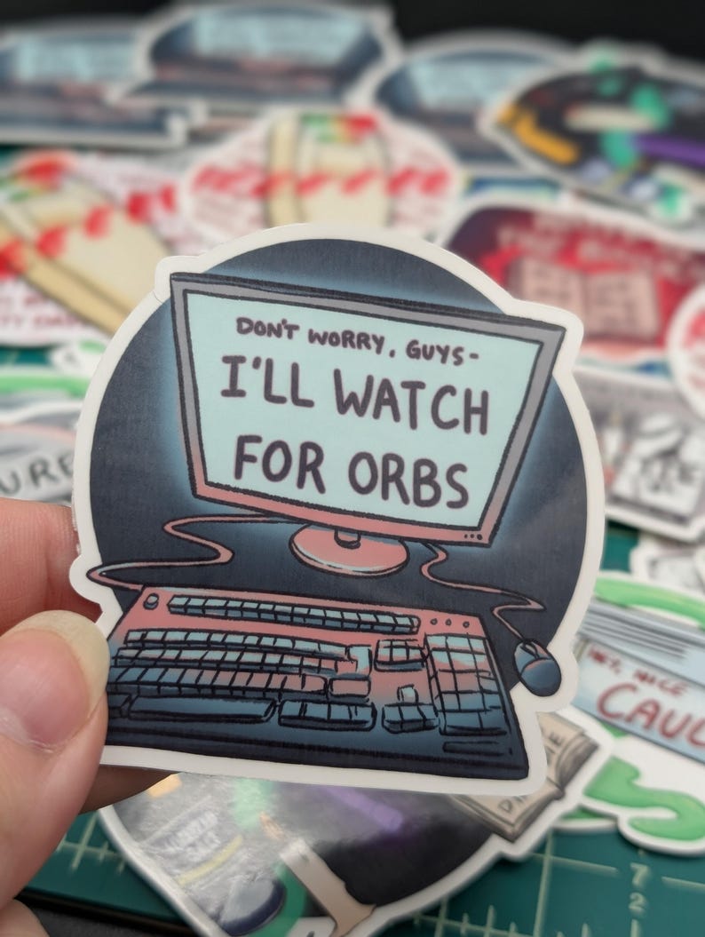 May include: A sticker with a cartoon illustration of a computer monitor and keyboard. The monitor screen displays the text "Don't worry, guys - I'll watch for orbs."