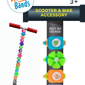 May include: A silver scooter with a colorful Wheely Bands accessory attached to the handlebar. The scooter has a red deck with the word "Razor" printed on it. The Wheely Bands accessory is a set of colorful plastic bands that can be attached to the handlebars of scooters and bikes. The Wheely Bands accessory is also available in a variety of other colors and designs. The packaging includes the text "Meet My Friends!" and "Unlikely Friends Collection".