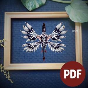 Pode incluir: Um padrão de bordado em ponto cruz apresentando uma criatura simétrica com quatro grandes asas emplumadas em tons de branco, cinza e preto. O design está centralizado em um tecido azul escuro, emoldurado em madeira clara e inclui o texto @iulia.